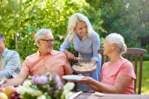Senior friends enjoying a meal outdoors at the Elkhorn luxury independent living
