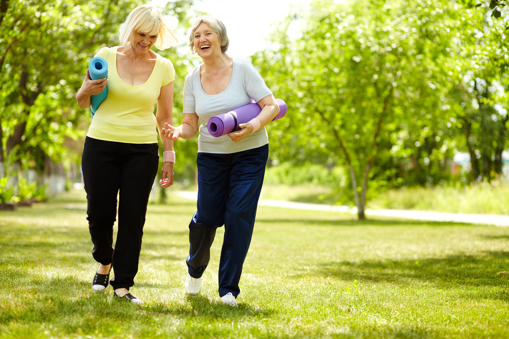 2 senior woman outdoors enjoying yoga at independent living Elkhorn