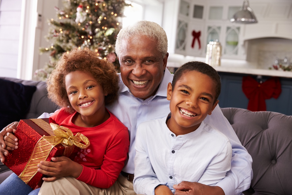 A senior man getting a visit from his grandchildren at the Elkhorn memory care community