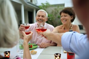 A group of senior friends toasting while eating dinner at the independent living in Elkhorn