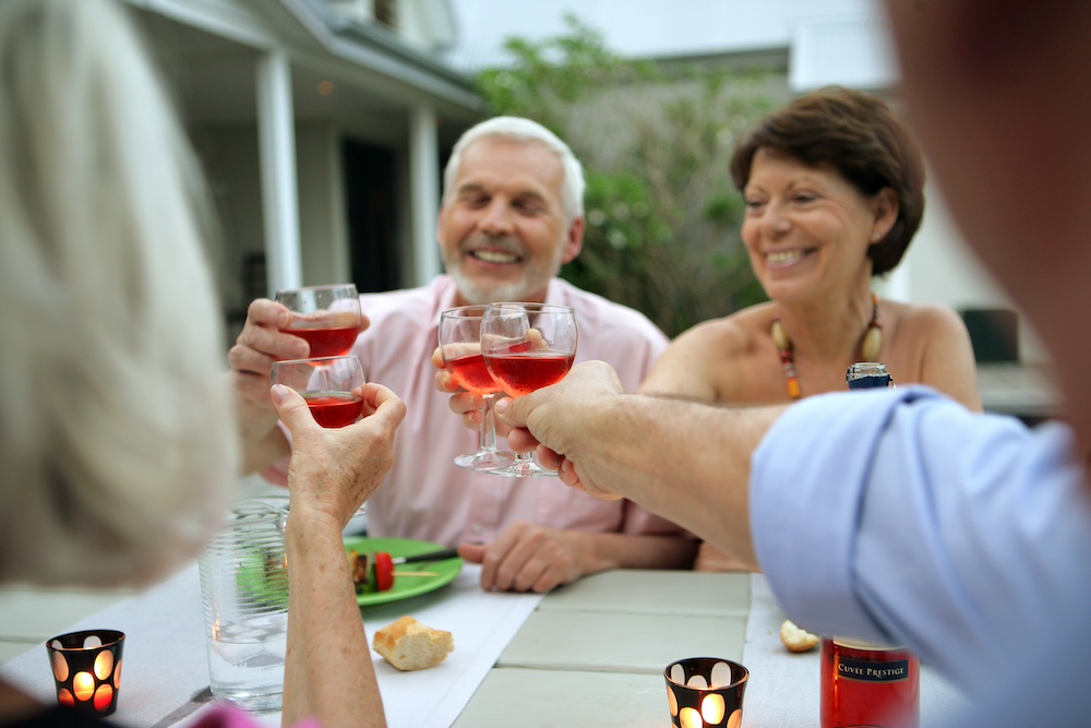 A group of senior friends toasting while eating dinner at the independent living in Elkhorn